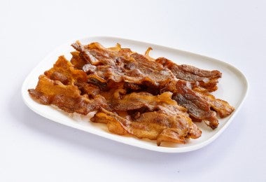 Tiras de bacon frito sobre un plato.