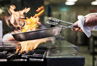 Chef utilizando pinzas de cocina multiusos al cocinar 