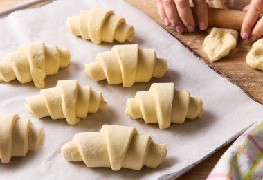 Siete croissants de almendras listos para hornear.