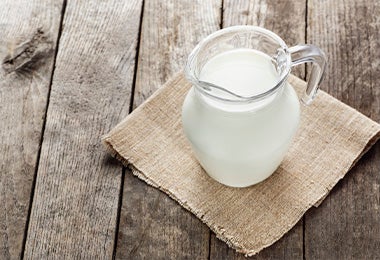 Una jarra de vidrio con leche para preparar yoghurt casero