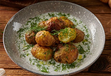 Plato de papas en casco espolvoreadas con cilantro para el Día Internacional de la Papa.