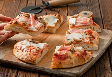 Pizza de prosciutto cortada en porciones 