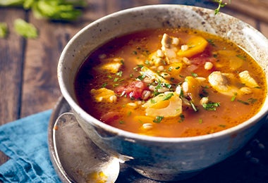 Sopa de tomate, papa y res, una receta de cocción lenta servido en un plato hondo.