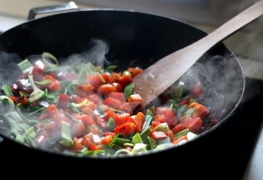 Verduras frescas cocinándose en wok para hacer chutney de mango y otras variantes