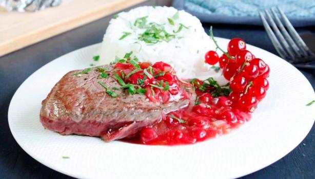 Plato de carne, arroz y salsa de grosellas