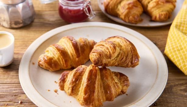 Tres deliciosos croissants de almendras frescos sobre un plato.